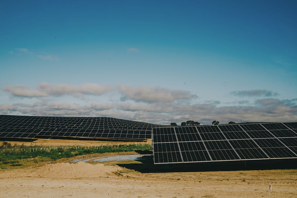 A vast solar farm in a desert setting under clear blue skies, showcasing renewable energy.